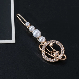 Detailed view of alloy star and pearl hair clip with rhinestones on black background
