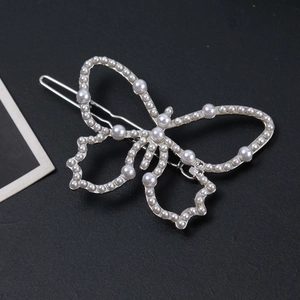 Gros plan détaillé sur la pince à cheveux papillon évidée avec perles et strass brillants