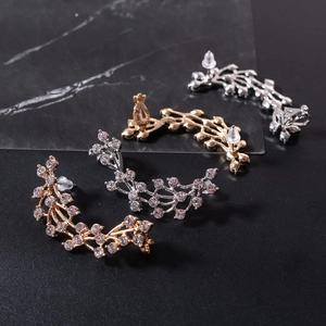 Detailed view of gold and silver vine branch ear crawlers with sparkling rhinestones