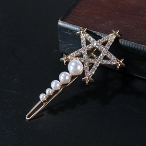 Star-shaped gold hair clip with sparkling rhinestones and graduated white pearls