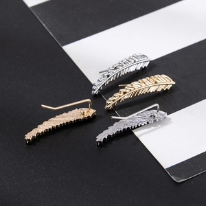 Detail of leaf feather ear crawlers in gold and silver finish with textured surface