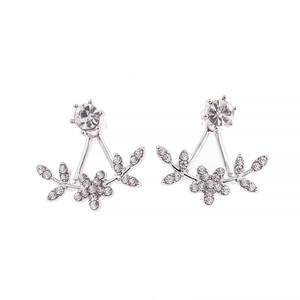 Macro detail of silver floral jacket earrings with sparkling rhinestones and petal accents