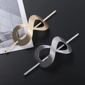 Detail of infinity figure-eight metal hairpins in gold and silver with matte brushed finish