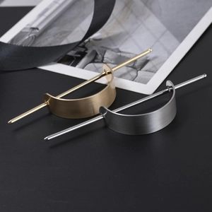 Minimalist curved metal hair clips in gold and silver with a matte brushed finish