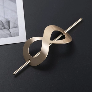 Elegant gold brushed metal hair pin featuring a hollow infinity loop design on black background