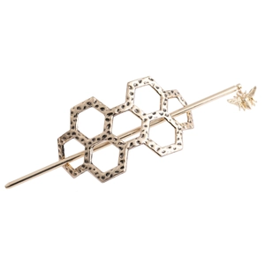 Detail of golden honeycomb hair pin with hammered texture and small bee pendant