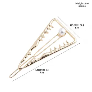 Détail d'une pince à cheveux triangulaire dorée avec perle indiquant la longueur de 7,1 cm