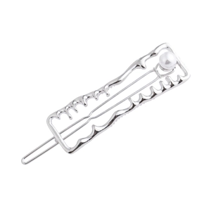 Detail view of silver alloy liquid metal hair clip with a white pearl accent
