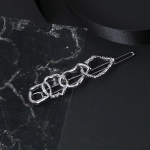 European abstract style silver hair clip with irregular chain rings on dark background