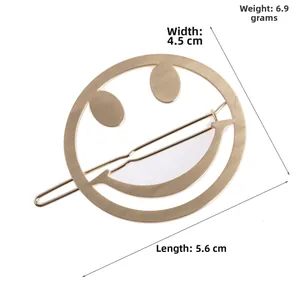 Vue détaillée de la pince à cheveux smiley dorée mate, dimensions 5,6 cm par 4,5 cm