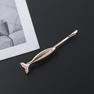 Elegant gold fish-shaped hair clip featuring glossy finish and white pearl accents
