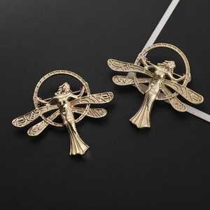 Art Nouveau style matte gold angel wings brooch showing intricate texture and circular frame