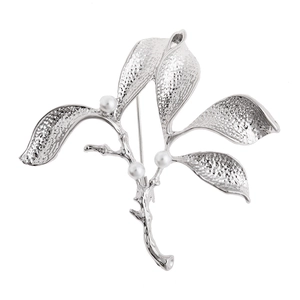 Elegant leaf branch brooch with pearls and hammered silver texture on white background