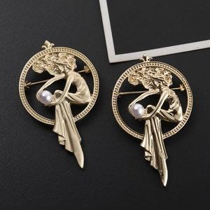 Detailed macro of golden portrait brooches featuring white pearls and ornate circular frames