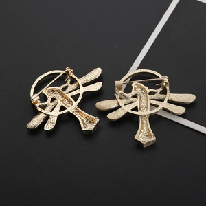 Detailed back view of golden dragonfly brooches with secure metal pin closure mechanism