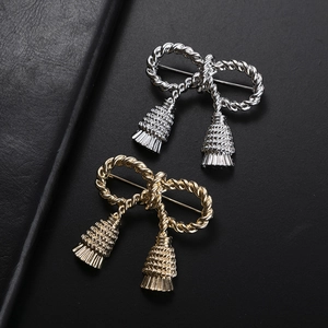 Elegant bow-shaped knot brooch in gold and silver finish with tassel details