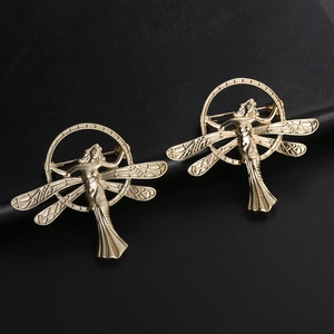 Golden vintage angel wing goddess brooch in a circular frame on black leather