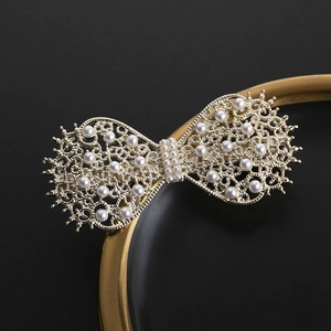 Elegant gold hollow butterfly hair clip with white pearls on a minimalist black background