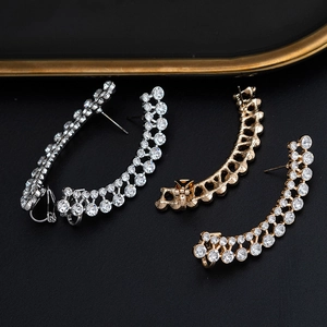 Macro detail of geometric long ear cuffs with sparkling crystals in gold and silver finish
