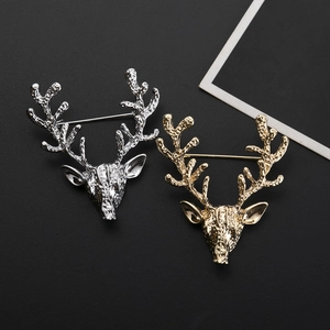 Gros plan de broches tête de cerf en or et argent avec texture de relief métallique