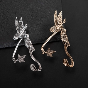 Elfenflügel-Ohrmanschetten in Silber und Bronze auf schwarzem Steinhintergrund