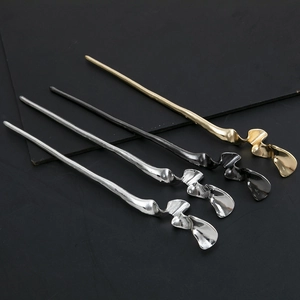 Detailed view of four irregular metal hair sticks in gold, silver, and black finishes