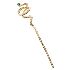 Détail d'une épingle à cheveux serpent dorée avec pierre précieuse verte et texture écailles