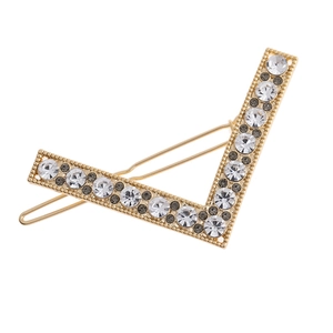 Close-up of golden V-shaped hair clip with sparkling white and grey rhinestones