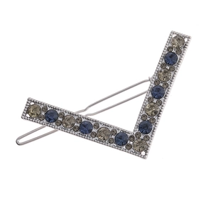 Close-up of V-shaped hair clip with blue and grey rhinestones on a metal base