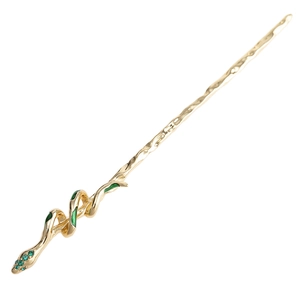 Close-up of golden snake hair pin with green rhinestones and enamel details