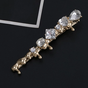 Détail de la barrette dorée style lave avec cinq cristaux clairs de formes variées
