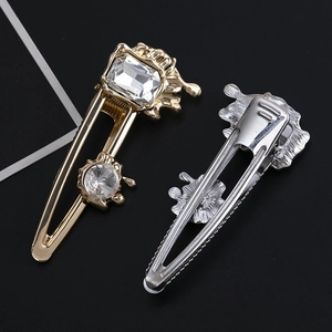 Detailed macro view of gold and silver hair clips with sparkling rectangular crystals