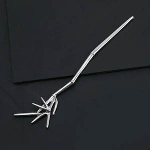 Close-up detail of silver bamboo joint hair stick with realistic leaf design on dark background