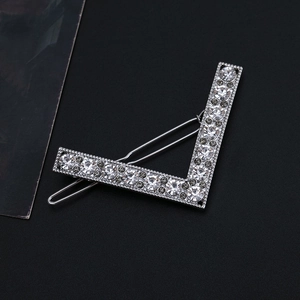 Close-up of V-shaped hair clip featuring mixed clear and grey rhinestones on silver metal