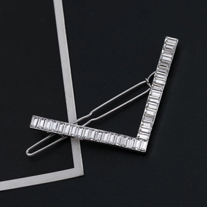 Minimalist V-shaped silver hair clip with rectangle white rhinestones on black background