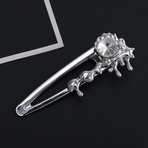 Pince à cheveux en métal argenté style lave avec un grand cristal sur fond noir