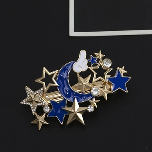 Detail einer Haarspange mit blauem Emaille-Mond und Sternen in Goldoptik