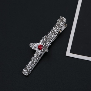 Vintage silver metal hair clip with floral patterns, butterfly decor, and a red rhinestone