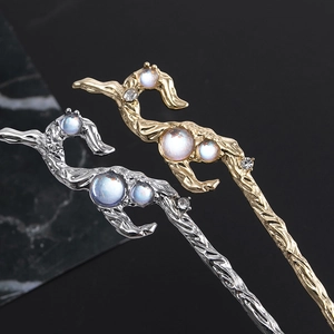 Macro detail of vintage branch hair pins with irregular texture and moonstone inlay