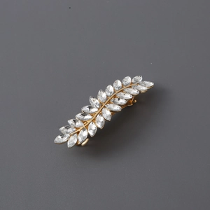Macro shot of elegant golden leaf hair clip featuring shimmering inlaid rhinestones