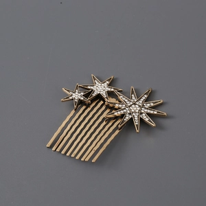 Close-up of vintage gold star hair comb with sparkling crystals and multiple teeth