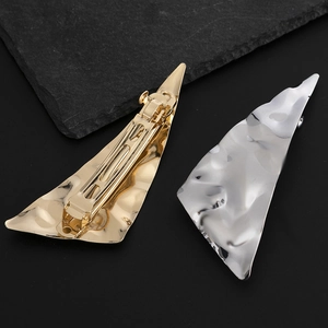 Modern gold and silver metallic hair clips with irregular hammered texture and spring clamp