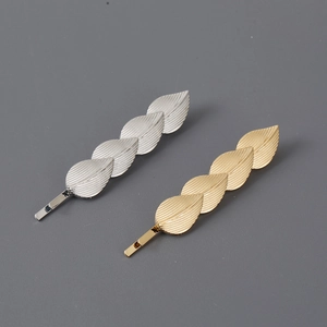 Minimalist metallic leaf hair pins in gold and silver finishes with realistic vein texture