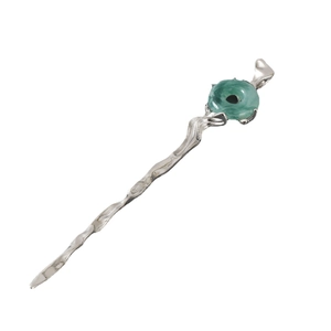 Detail of silver wavy metal hair stick with a translucent green jade-like ring accent