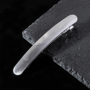 Vue détaillée d'une barrette argentée à texture brossée sur fond d'ardoise noire