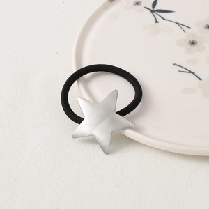 Elastic black hair tie with a frosted silver star metal charm on a clean background