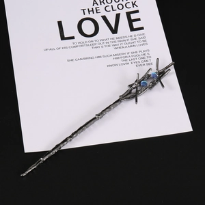 Detailed view of silver branch hairpin with two blue opal-like gemstones in gothic style