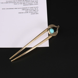 Detail of vintage U-shaped hair pin with turquoise stone and bronze metal texture