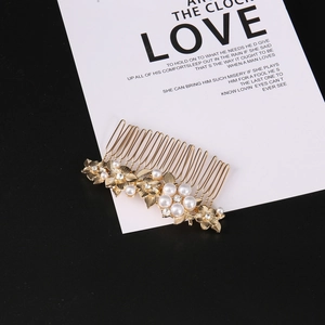 Detailed view of golden flower hair comb with white pearls and sparkling rhinestones