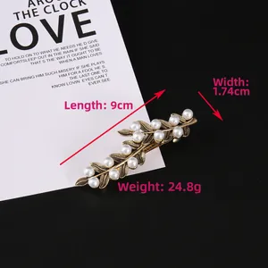 Detail view of pearl leaf hair clip with dimensions 9cm by 1.74cm on a stylish card